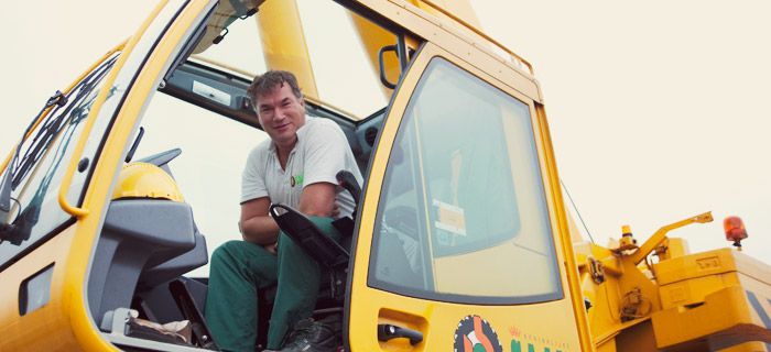 ouvrier de chantier dans une pelleteuse jaune